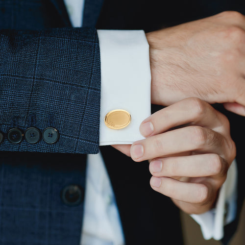 Image of man's suit showing oval yellow gold oval cuffink on navy suit white shirt cuff